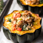 Roasted sausage stuffed acorn squash with parmesan cheese and vegetables