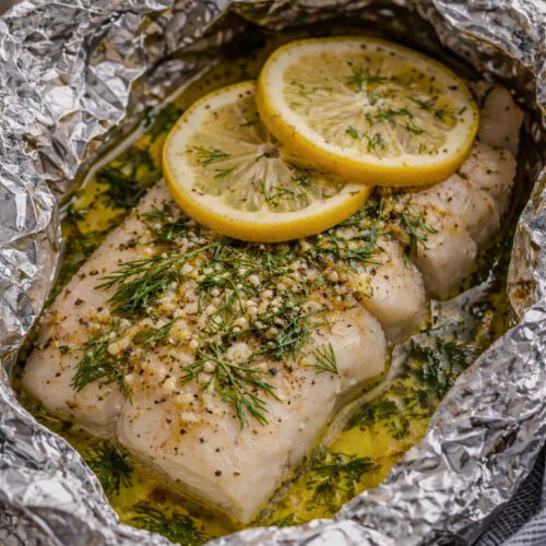 Foil-baked cod fillet with lemon slices and fresh dill, tender and flaky