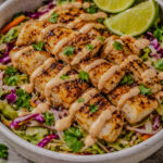 Fish taco bowl with seasoned fish, slaw, and spicy mayo drizzle