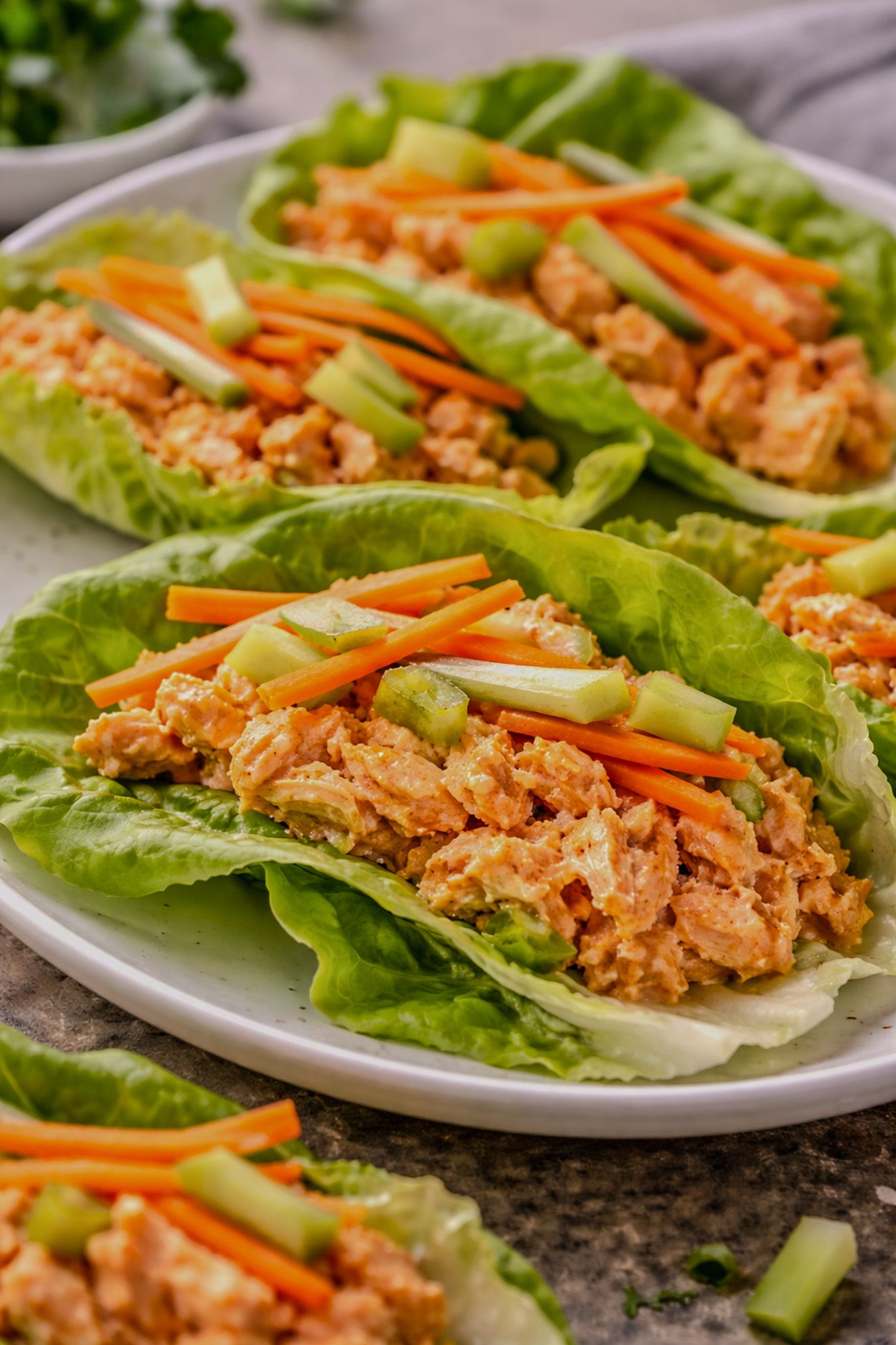 Buffalo chicken lettuce wraps with celery and carrots on a plate