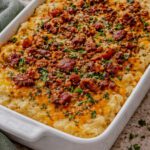 Baked cheesy mashed potatoes topped with bacon, chives, and toasted panko crumbs