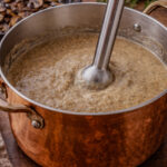 Creamy chestnut mushroom soup topped with sautéed mushrooms and thyme in a bowl