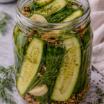 Homemade refrigerator dill pickles in a mason jar with fresh dill, garlic, and spices