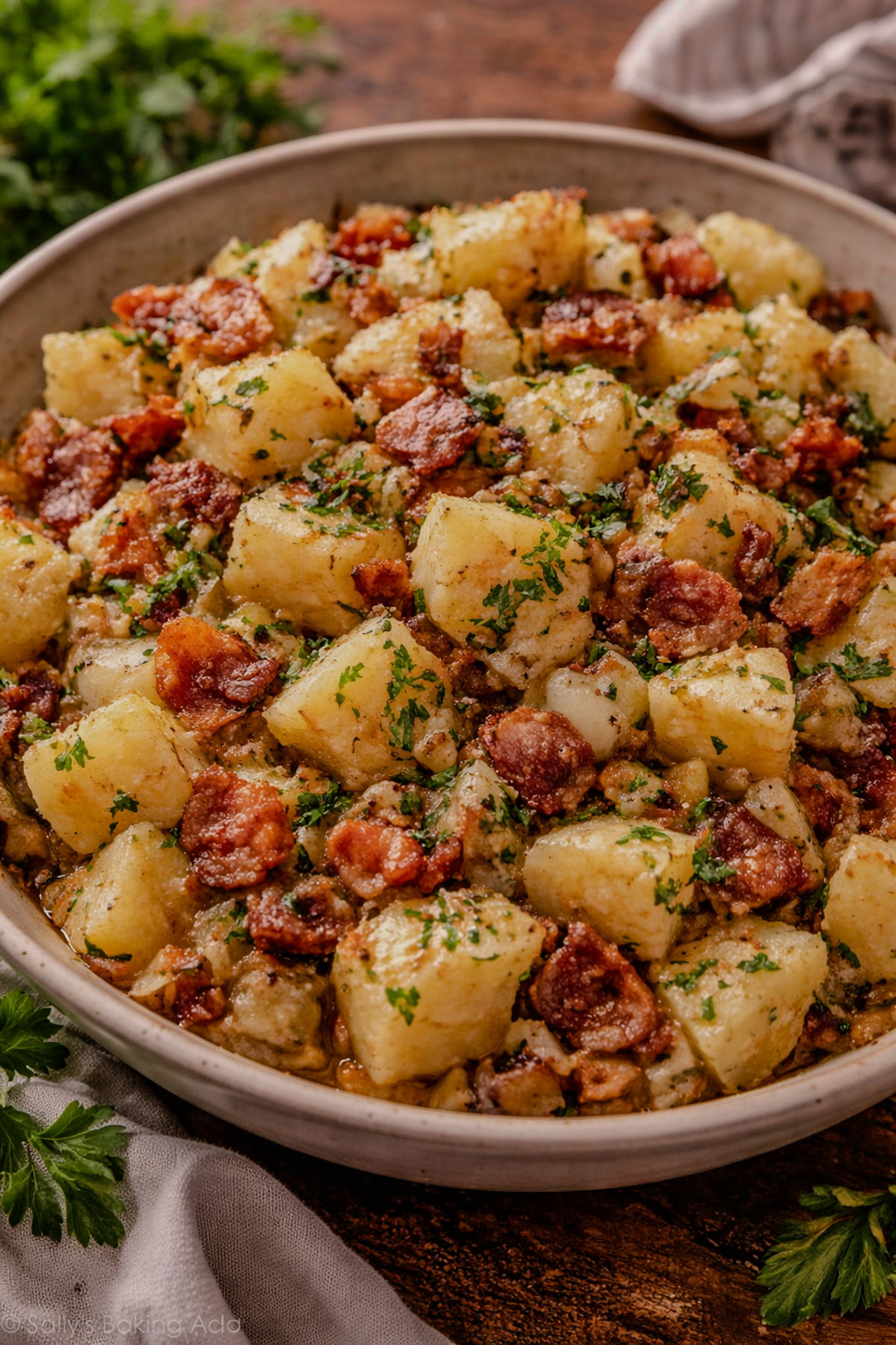 Warm German potato salad with bacon and parsley served in a bowl