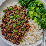 Korean ground beef and broccoli served over rice with green onions and sesame seeds