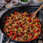 Healthy Kung Pao chicken with peanuts, red peppers, and celery in a skillet