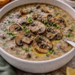 Creamy mushroom soup without cream garnished with sautéed mushrooms and fresh herbs