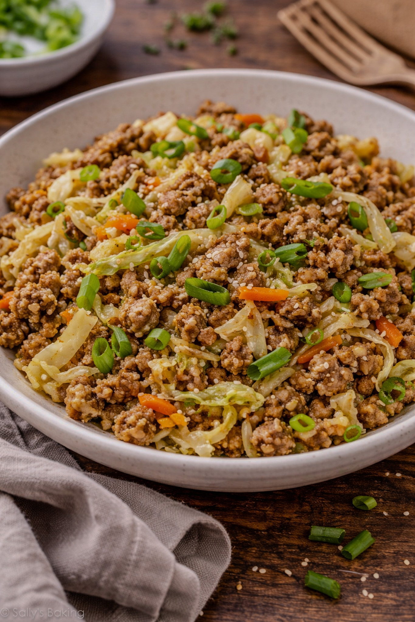 Pork fried cauliflower rice with ground pork, cabbage, carrots, and green onions cooked in a skillet