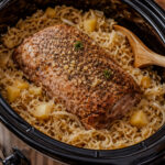 Slow cooker pork and sauerkraut with tender pork pieces simmered in tangy sauerkraut