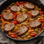 Seared pork tenderloin slices with sweet bell peppers and pepperoncini in a skillet