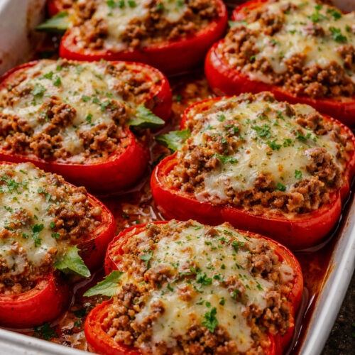 Easy weeknight stuffed peppers baked with ground beef, rice, tomato sauce, and melted mozzarella in a casserole dish