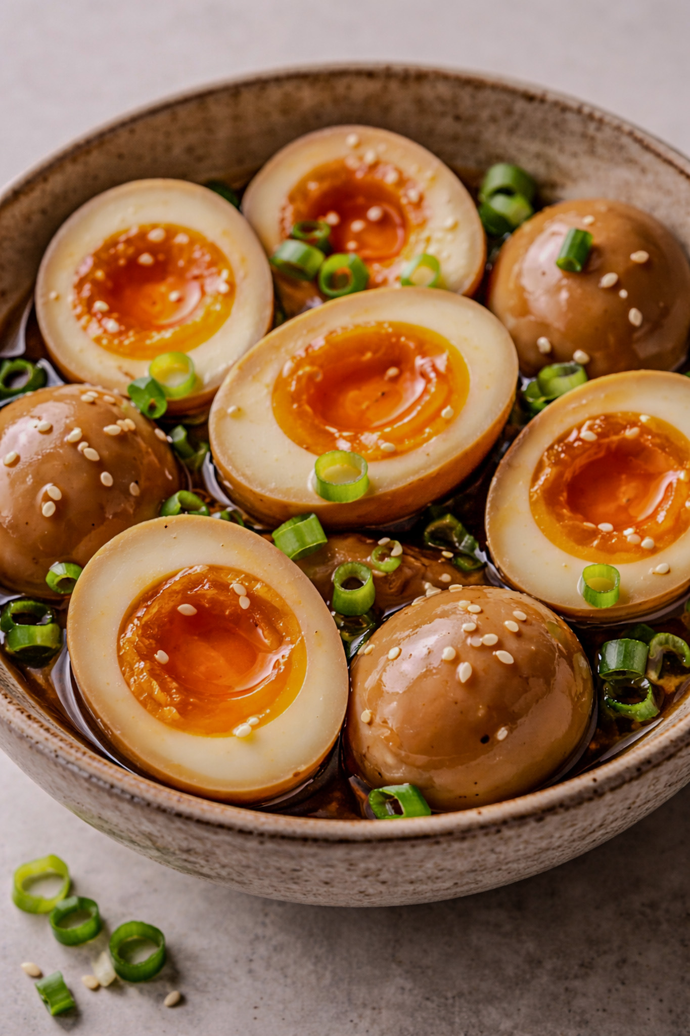 Ajitama eggs sliced in half showing jammy yolks and soy-marinated bronze whites.