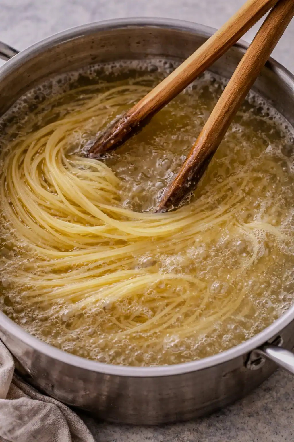 Spaghetti cooking in a pot of boiling water, with strands beginning to soften and separate.