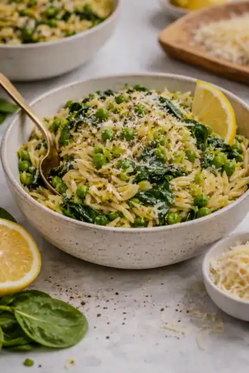 Lemon orzo salad with peas, spinach, and parmesan in a bowl