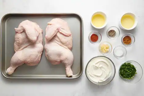 Raw chicken thighs ready for cooking with herbs and spices for flavor.